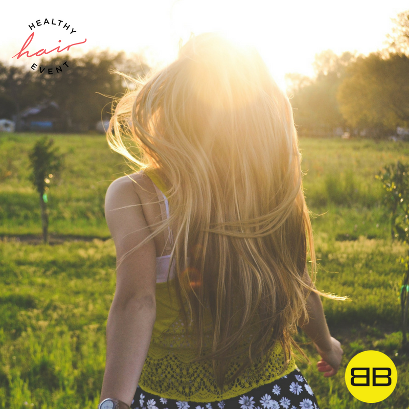 Top 3 Ways Stress Wrecks Your Hair | Image of woman running in a field with sunshine in her hair