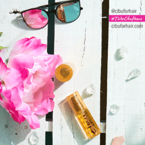 Image of Cibu Shine Squad Argan Oil on beach deck with reflective sunglasses and pink flower \ Protect Summer Hair